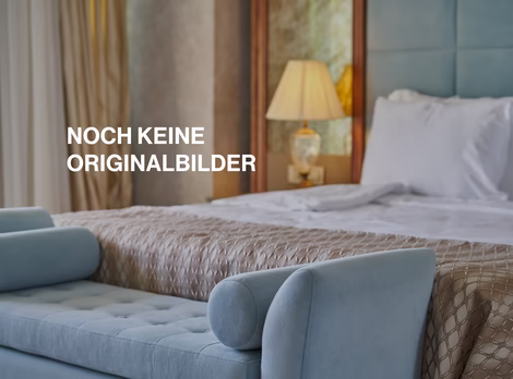Detailaufnahme von Blauer Sitzcouch vor einem Doppelbett