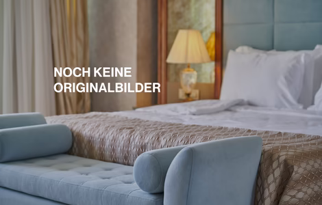 Detailaufnahme von Blauer Sitzcouch vor einem Doppelbett