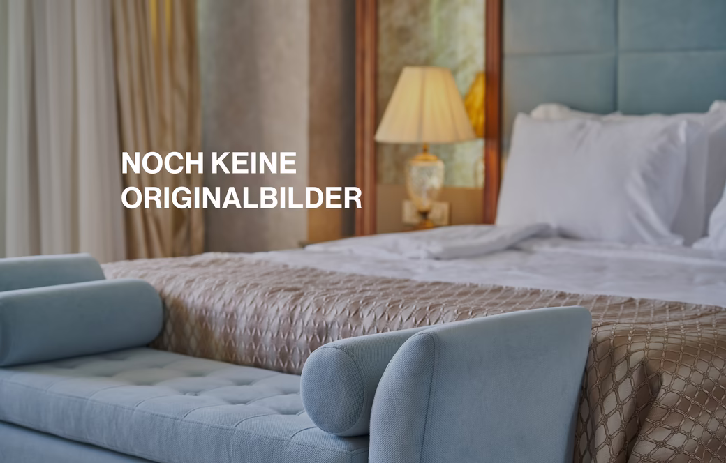 Detailaufnahme von Blauer Sitzcouch vor einem Doppelbett